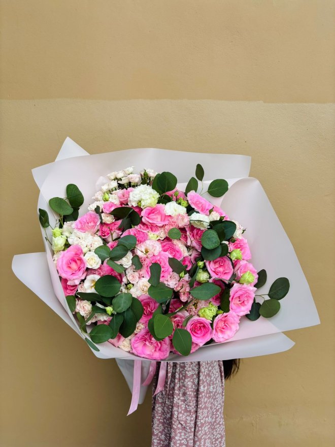 Large bouquet of pink roses, pink lisianthuses, white spray roses, green carnations, and foliage.