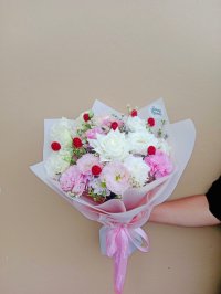 Bouquet of white roses, pink lisianthuses, white carnations, wax flowers, and red gomphrena.