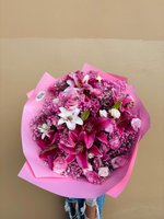 Pink and white bouquet with roses, lilies, and orchids in pink wrapping