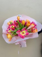 Pink and orange tulip bouquet wrapped in light pink paper