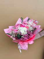 Pink Present bouquet featuring pink gerberas, white and pink chrysanthemums, and baby's breath wrapped in pink paper with decorative picks
