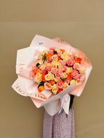 Heavenly Sensation bouquet with peach, coral, and blush roses wrapped in soft pink paper.