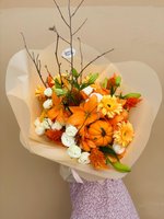 Autumn Charm bouquet with orange lilies, white roses, yellow chrysanthemums, decorative mini pumpkins and branches wrapped in cream paper