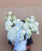 White bouquet with roses, hydrangeas, and lisianthus in a decorative box