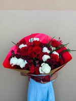 Hand-tied bouquet with red and white roses, burgundy chrysanthemums, and evergreen sprigs wrapped in vibrant red paper